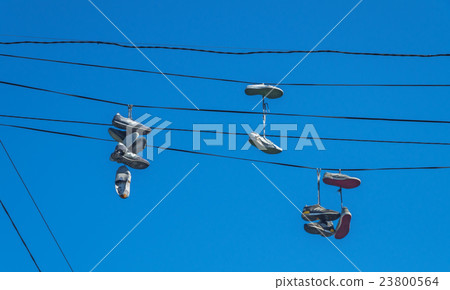 Shoes hanging on wires 23800564