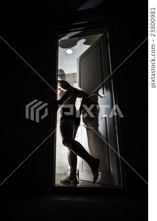 Man enters opening door from black room Man enters opening door from black room 23800981