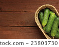Cucumbers in a basket on wooden background 23803730