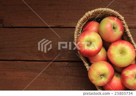 Apples in a basket on wooden background 23803734