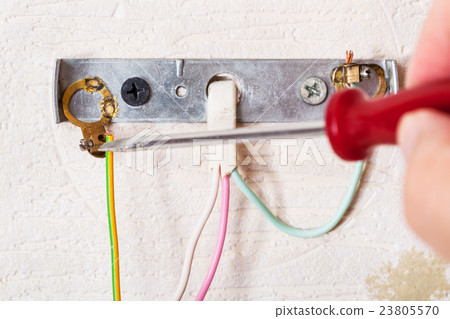 Electrician repairs wiring in wall light Electrician repairs wiring in wall light 23805570