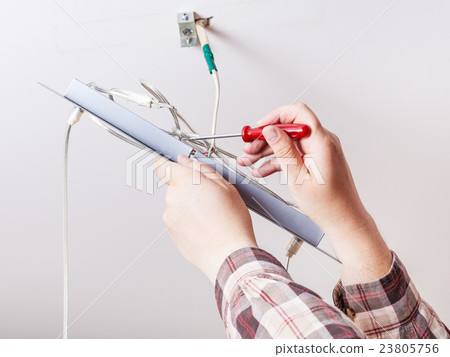 Electrician repairs wiring in ceiling lamp Electrician repairs wiring in ceiling lamp 23805756