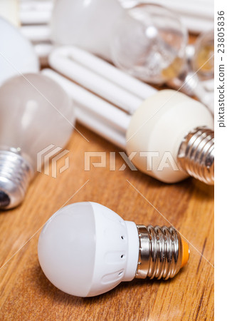 energy saving LED lamp and pile of old bulbs 23805836