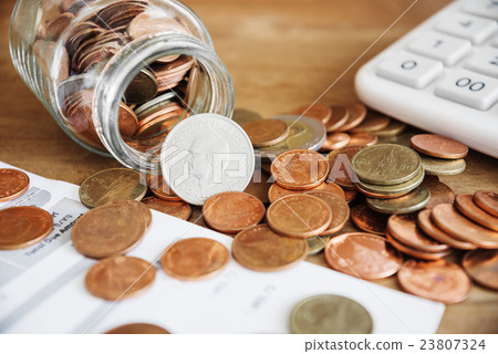 Coins spilling out of a glass bottle Coins spilling out of a glass bottle 23807324