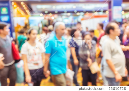 Blurred people walking in the exhibition hall. 23810728