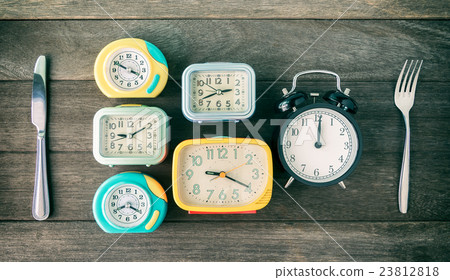 Time to eat concept. Clocks,spoon and folk on wood 23812818