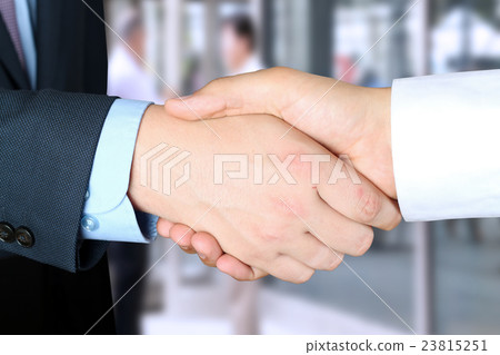 Firm handshake  between two colleagues outside 23815251