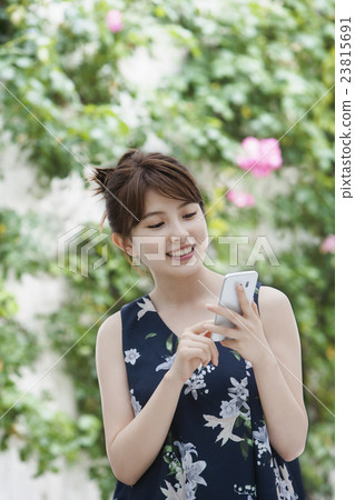 A young woman operating a smartphone 23815691