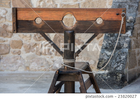Old pillory on castle stone wall background 23820027