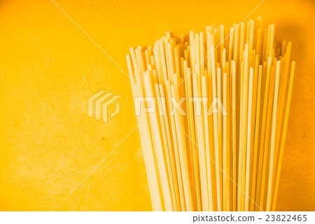 Raw spaghetti on the yellow background horizontal Raw spaghetti on the yellow background horizontal 23822465