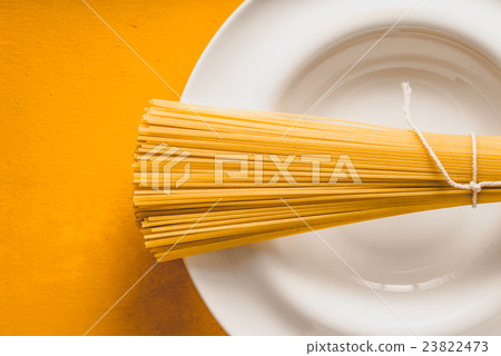 Raw spaghetti  on the  plate on the background  23822473