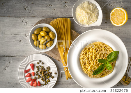 Raw and cooked spaghetti with different appetizer 23822676