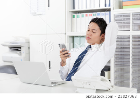 Businessman fiddling with mobile phones 23827368