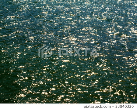 Blue green sea level, sun reflections on waves. 23840320