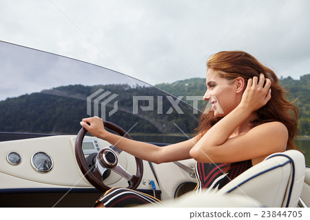 Summer vacation - young woman driving a motor boat Summer vacation - young woman driving a motor boat 23844705