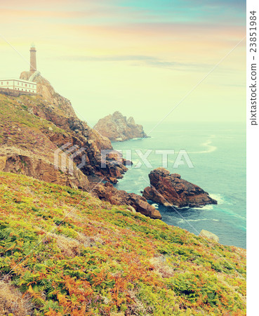 toned photo with lighthouse on rocky coast 23851984