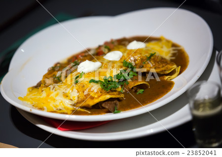 Mexican enchillada stuffed with juicy meat on plate 23852041