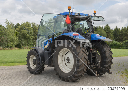 Modern blue tractor on a farmyard. Modern blue tractor on a farmyard. 23874699