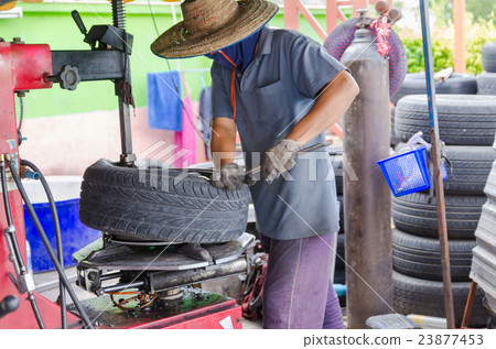 The man removing car tire 23877453