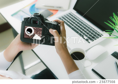 photographer holding camera checking photo 23877508