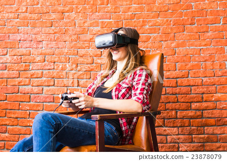 Woman play video game with joystick and VR device Woman play video game with joystick and VR device 23878079