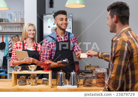 Barista serving client give card paying bill at 23879729