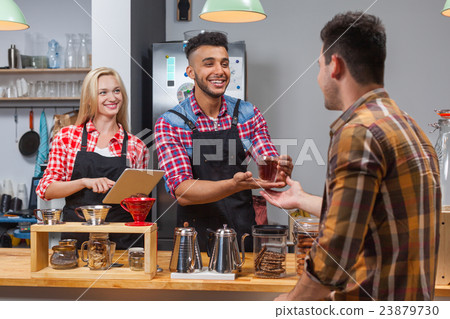 Barista serving client give glass tea coffee shop 23879730