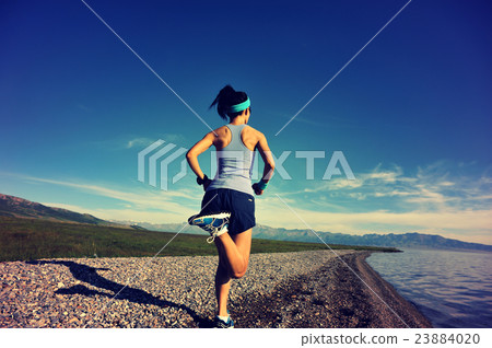 young fitness woman running on sunrise seaside 23884020