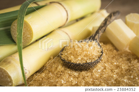 granulated brown in a wooden spoon granulated brown in a wooden spoon 23884352