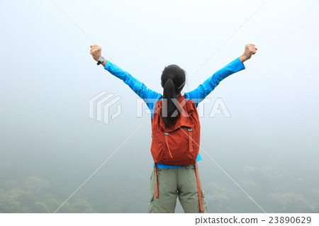 cheering young woman open arms on mountain peak cheering young woman open arms on mountain peak 23890629