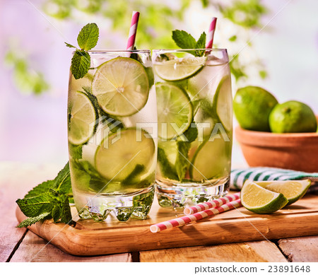 On wooden boards is glass with mohito and lime. 23891648