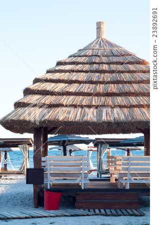 Sun loungers under an umbrella 23892691