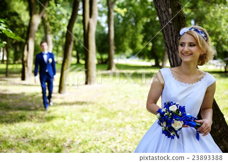 Groom approaches the bride in park Groom approaches the bride in park 23893388