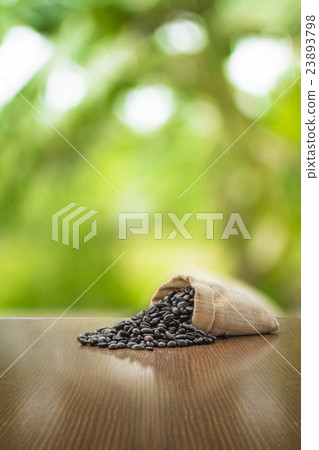 Coffee beans on wooden table in green background 23893798