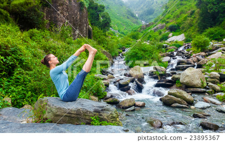 Woman doing Ashtanga Vinyasa Yoga asana outdoors 23895367