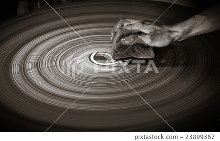 Man's hand on a potter's wheel 23899367