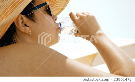 Thirsty female is drinking water at the beach 23901472