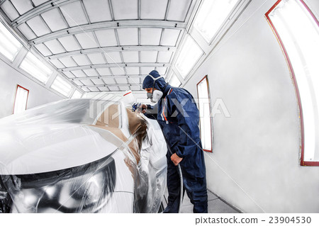 worker painting a white car in special garage worker painting a white car in special garage 23904530