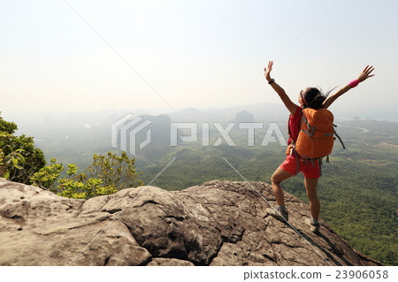 woman hiker enjoy the view at mountain peak cliff woman hiker enjoy the view at mountain peak cliff 23906058