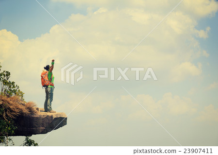 young woman hiker on mountain peak cliff young woman hiker on mountain peak cliff 23907411
