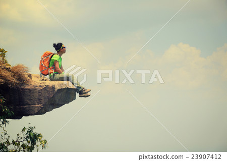 young woman hiker on mountain peak cliff 23907412