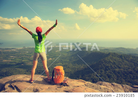 cheering woman hiker open arms on mountain peak 23910185