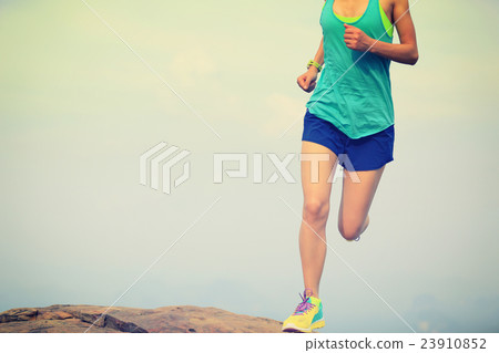 young asian woman runner running on mountain peak young asian woman runner running on mountain peak 23910852