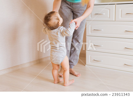 Cute smiling baby boy learning to walk Cute smiling baby boy learning to walk 23911343