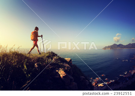 woman hiker hiking on sunrise seaside mountain  23912551