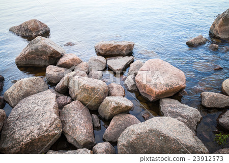 Coastal granite stones lay in still lake 23912573