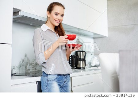 woman sitting on the couch with a cup 23914139