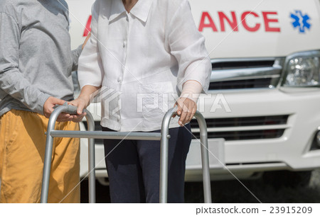 senior woman using a walker with caregiver  23915209
