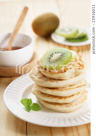 pancakes with honey syrup and fresh kiwi sliced 23916011