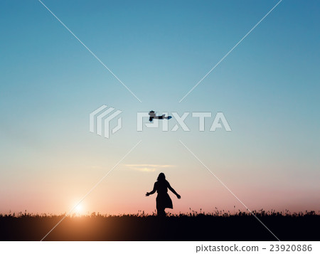 Silhouette of a beautiful girl jumping over sunset 23920886